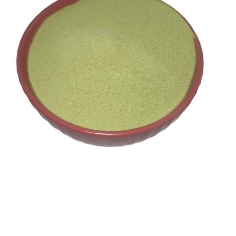 Top view of a Premium Matcha Milk Tea Powder in a traditional red bowl isolated on a white background. The bowl is filled with bright green, finely ground Premium Matcha Milk Tea Powder.